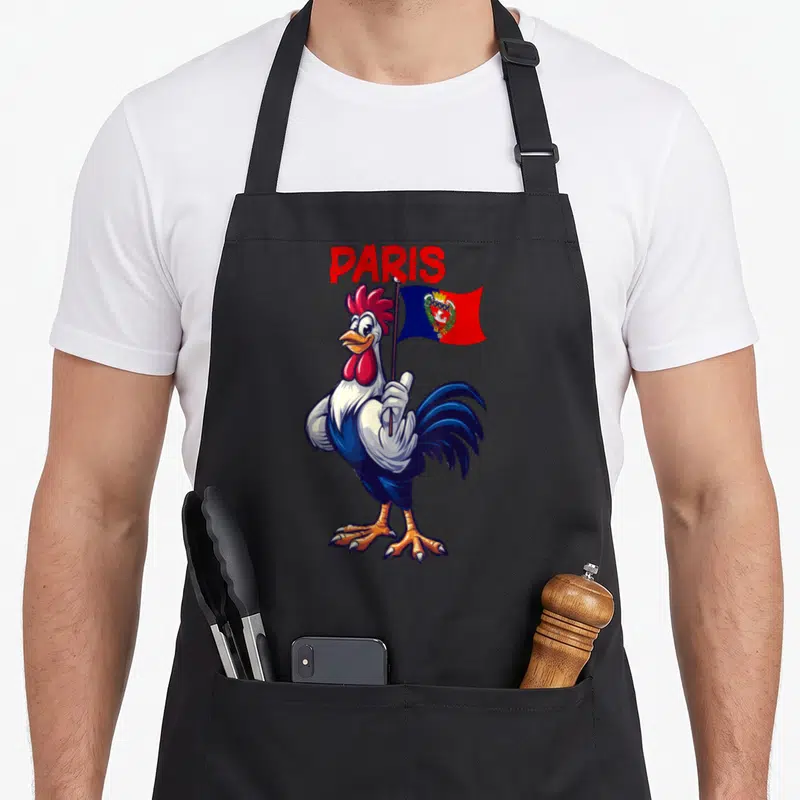 Tablier de cuisine noir avec coq tenant un drapeau bleu et rouge sous le mot PARIS en lettres rouges.