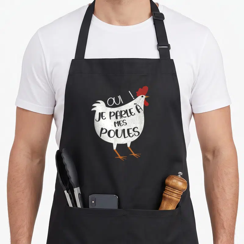 Tablier de cuisine noir avec une illustration de poule blanche et le texte « OUI ! JE PARLE À MES POULES » en gris et rouge.