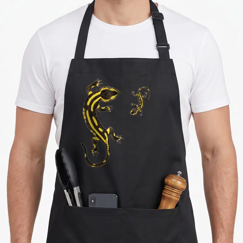 Tablier de cuisine noir avec illustration vintage de deux salamandres noires et jaunes aux motifs distinctifs.