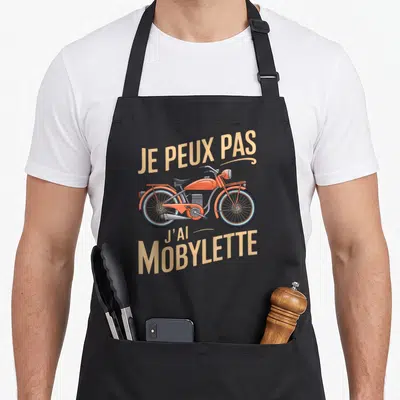 Tablier de cuisine noir avec illustration rétro d'une Mobylette orange et texte Je peux pas j'ai Mobylette en beige.