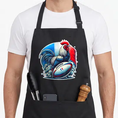 Tablier de cuisine noir avec illustration colorée d'un coq tenant un ballon de rugby français.