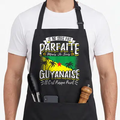 Tablier de cuisine noir avec inscription Je ne suis pas parfaite mais je suis Guyanaise et c'est presque pareil sur fond de drapeau.