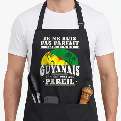 Tablier de cuisine noir avec linscription Je ne suis pas parfait mais je suis Guyanais et cest presque pareil sur fond de drapeau guoyen