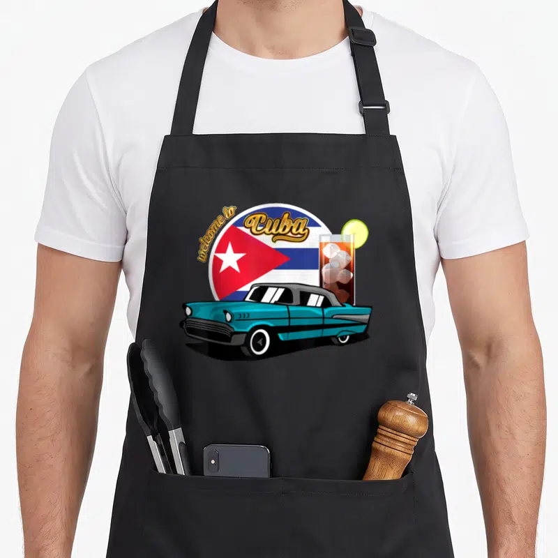 Tablier de cuisine noir avec voiture vintage turquoise, drapeau Cuba et cocktail Cuba Libre sur fond circulaire.