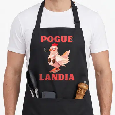 Tablier de cuisine noir avec une poule Pogue Landia en soutien-gorge de noix de coco fumant et sandales orange.