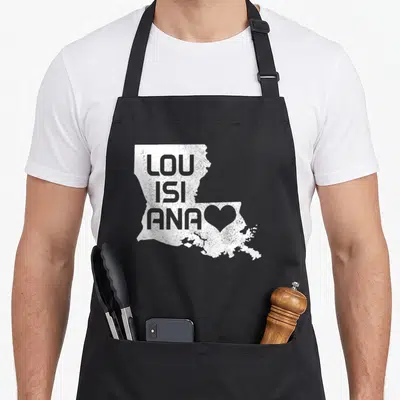 Tablier de cuisine noir avec carte blanche de la Louisiane et texte LouiSiana Love en typographie déstructurée.