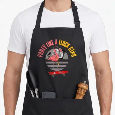 Tablier de cuisine noir avec un flamant rose rose vif sur skateboard rouge portant des écouteurs et une chaîne dorée devant une boombox.