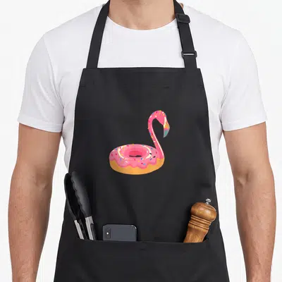 Tablier de cuisine noir avec illustration d'un beignet flamant rose aux paillettes colorées.