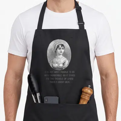 Tablier de cuisine noir avec portrait vintage d'une femme et citation anglaise humoristique en gris.