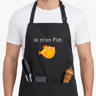 Tablier de cuisine noir avec le texte Je m'en Fish et un poisson orange stylisé