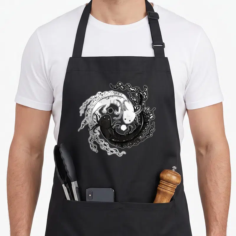 Tablier de cuisine noir avec illustration d'axolotls Yin Yang kawaii noirs et blancs en cercle.