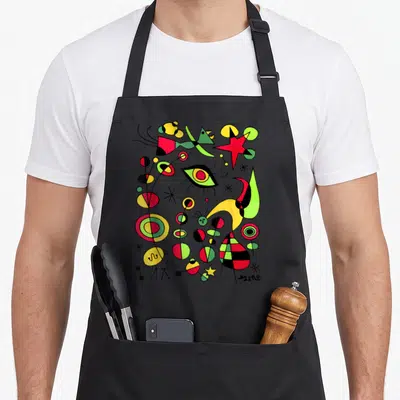 Tablier de cuisine noir avec une illustration abstraite colorée de Joan Miró incluant des formes organiques et une signature visible.