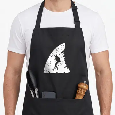 Tablier de cuisine noir avec illustration blanche d'un aileron de requin et d'un plongeur en silhouette.