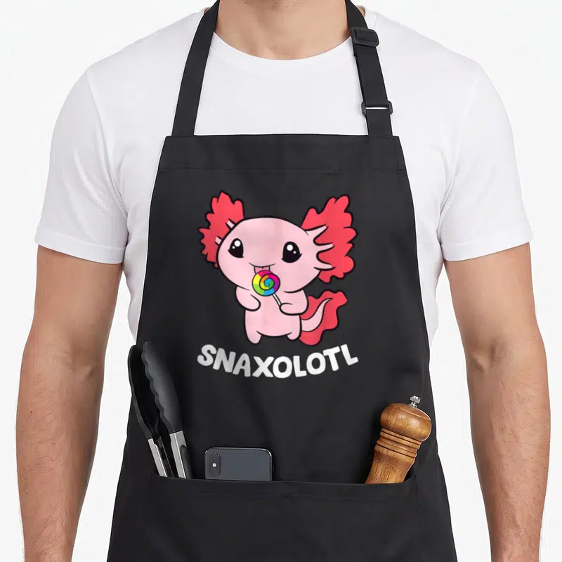 Tablier de cuisine noir avec un axolotl rosetenant une sucette multicolore et l'inscription Snaxolotl en bas.