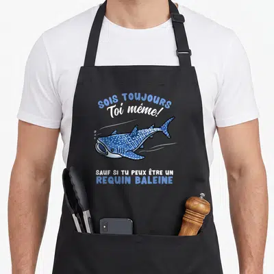 Tablier de cuisine noir avec illustration d'un requin baleine bleu et blanc et texte humoristique en français.