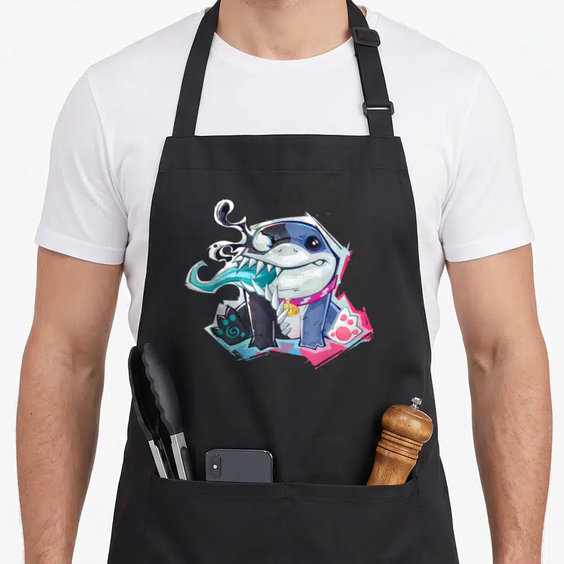 Tablier de cuisine noir avec un requin bleu stylisé Venom aux dents acérées et collier doré.