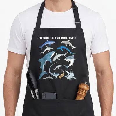 Tablier de cuisine noir avec illustration de divers requins et texte Future Shark Biologist en haut.