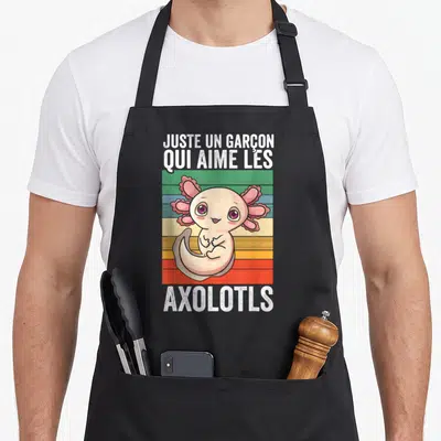 Tablier de cuisine noir avec illustration d'un axolotl rose et texte blanc sur fond rayé coloré vintage