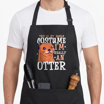 Tablier de cuisine noir avec illustration d'un loutre orange et texte blanc This is my human costume I'm really an otter