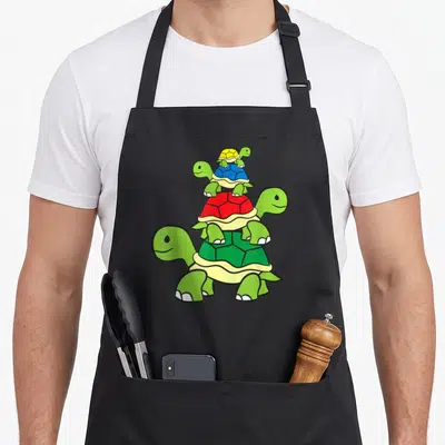 Tablier de cuisine noir avec quatre tortues vertes empilées aux carapaces colorées.