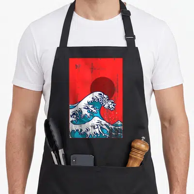Tablier de cuisine noir avec une illustration de La Grande Vague du Japon sur fond rouge et soleil sombre.