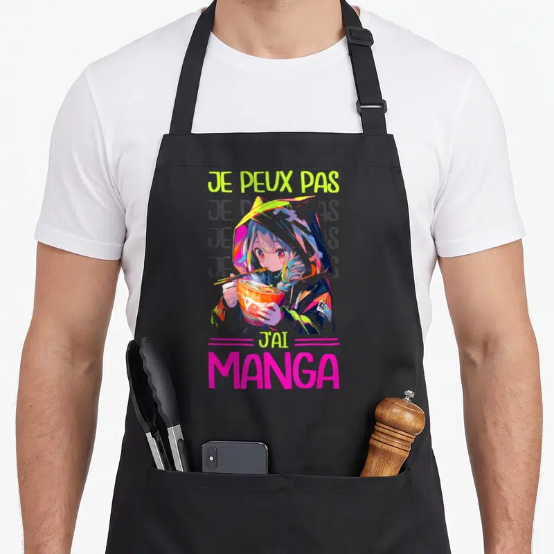 Tablier de cuisine noir avec une illustration d'otaku mangeant des ramen et le texte Je peux pas j'ai manga en lettres vives.