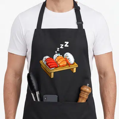 Tablier de cuisine noir avec trois sushis cartoon endormis et des Z en blanc.