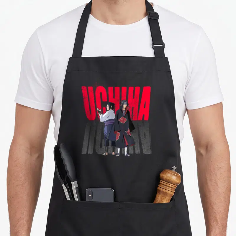 Tablier de cuisine noir avec Itachi et Sasuke Uchiha devant un logo UCHICHA rouge texturé et un effet de trame haltonnée grise.