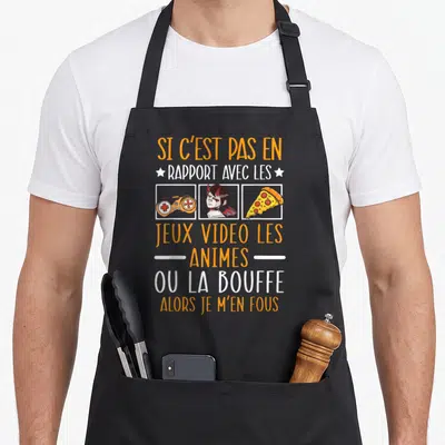 Tablier de cuisine noir avec inscription orange et blanche illustrée d'une manette, d'un personnage et d'une pizza.