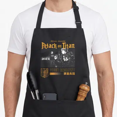 Tablier de cuisine noir avec illustration Attack on Titan Final Season Scout Regiment et logo des ailes de liberté en orange.