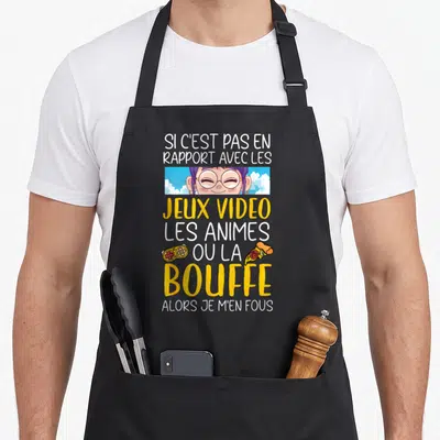 Tablier de cuisine noir avec une fille aux cheveux violets et le texte sur les jeux vidéo, animes et la bouffe.