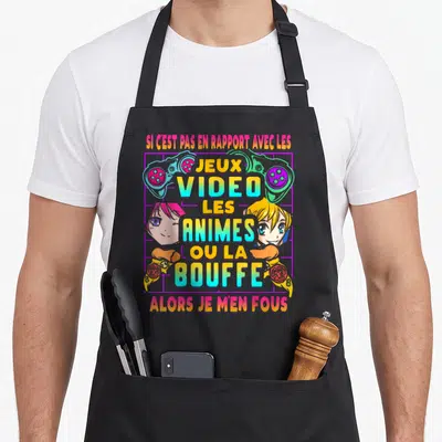 Tablier de cuisine noir avec texte humoristique sur jeux vidéo et animes entouré de deux têtes de personnages manga et de manettes de jeu colorées.