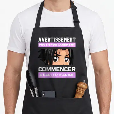 Tablier de cuisine noir avec un personnage d'animation et le texte Avertissement peut spontanément commencer à parler d'anime.