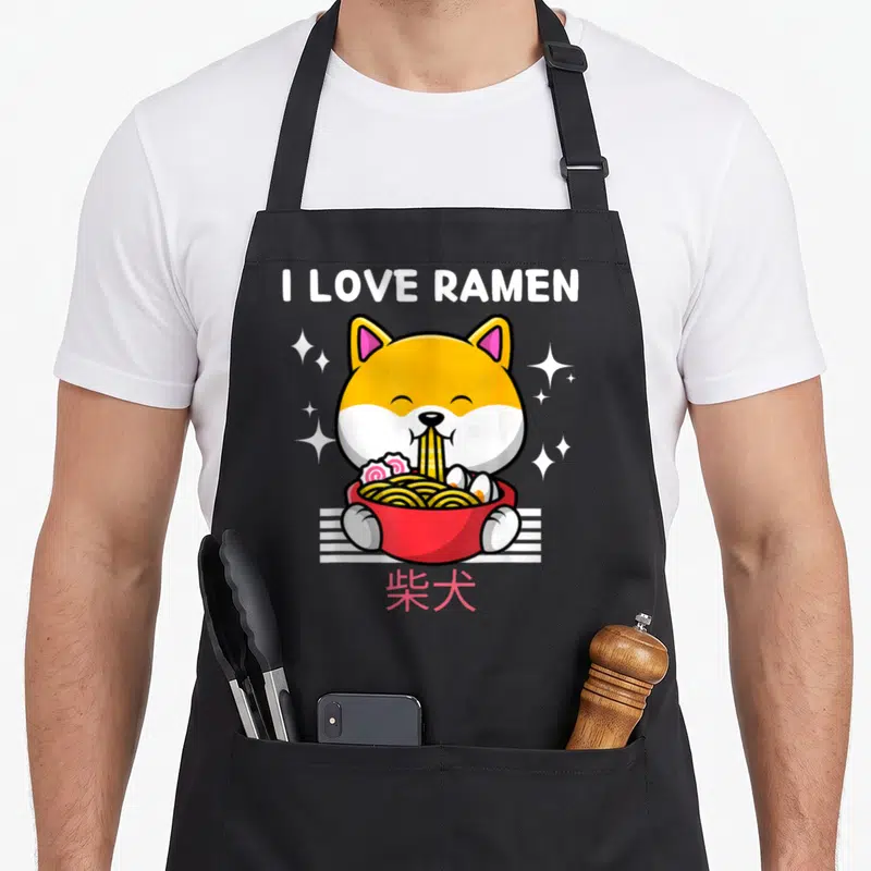 Tablier de cuisine noir avec un Shiba Inu mangeant du ramen et le texte I LOVE RAMEN en blanc.