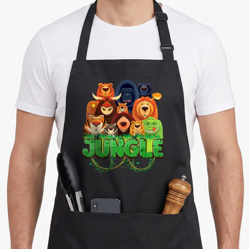 Tablier de cuisine noir avec illustration colorée d'animaux de la jungle et le mot JUNGLE en lettres vertes stylisées.
