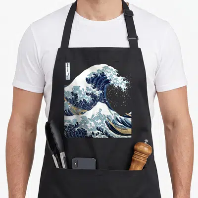Tablier de cuisine noir avec reproduction de La Grande Vague de Hokusai et ses bateaux en pleine mer.