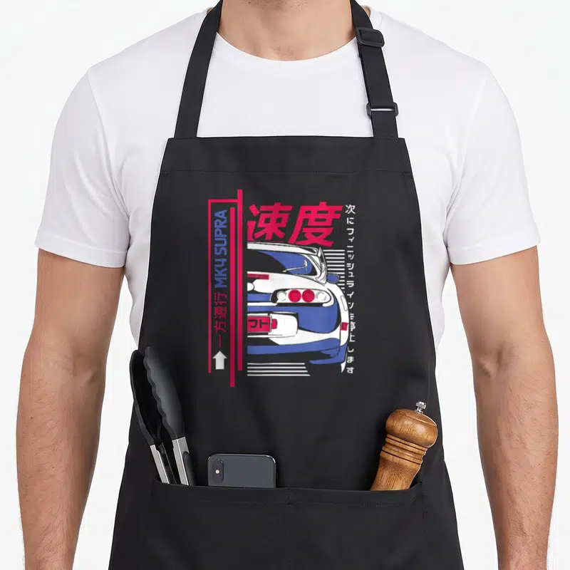 Tablier de cuisine noir avec illustration arrière Supra MK4, texte et bandes roses verticales.