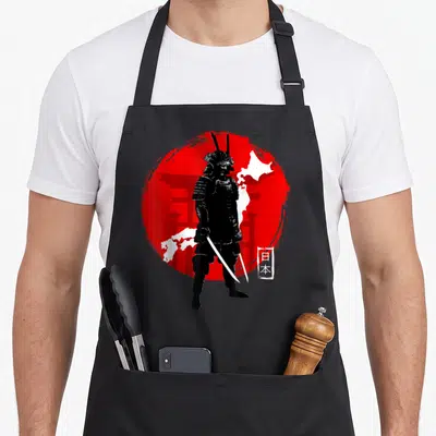 Tablier de cuisine noir avec illustration d'un samouraï ninja sombre sur fond de disque rouge et silhouette blanche du Japon.