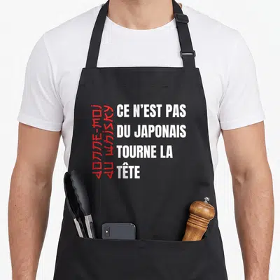 Tablier de cuisine noir avec texte blanc Ce n'est pas du japonais et caractères rouges verticaux.