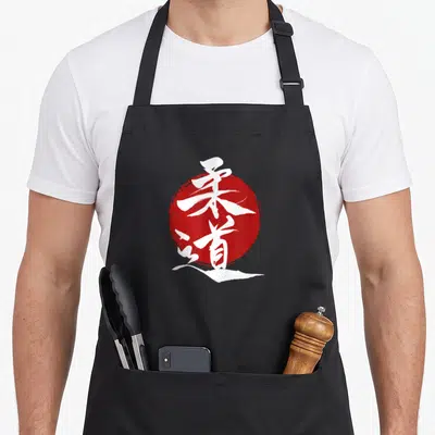 Tablier de cuisine noir avec une illustration de kanjis blancs superposés à un disque rouge circulaire.