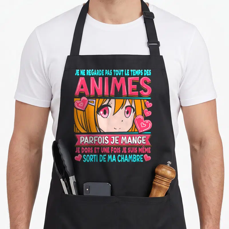 Tablier de cuisine noir avec une illustration kawaii orange et rose et un texte humoristique sur les animes.