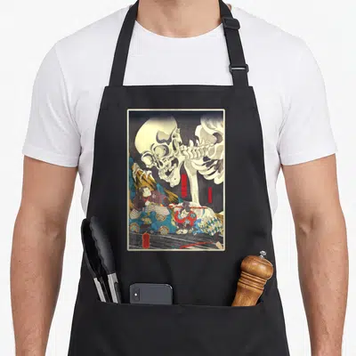 Tablier de cuisine noir avec une illustration d'estampe japonaise représentant un squelette géométrique et deux guerriers samouraïs en combat.