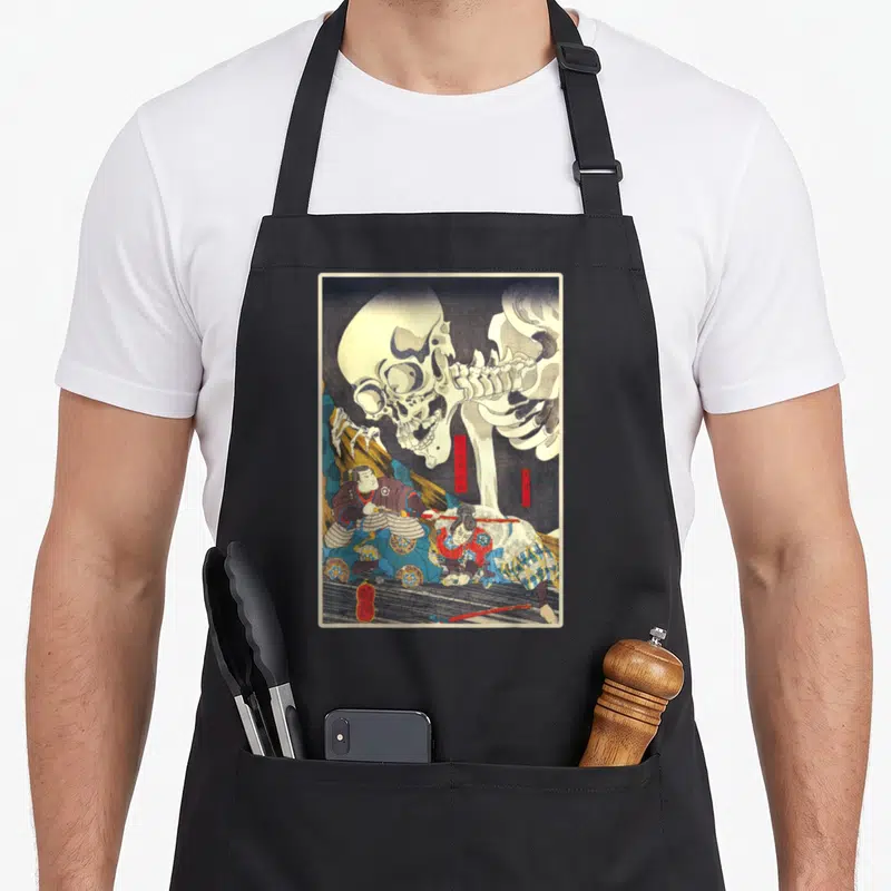 Tablier de cuisine noir avec une illustration d'estampe japonaise représentant un squelette géométrique et deux guerriers samouraïs en combat.