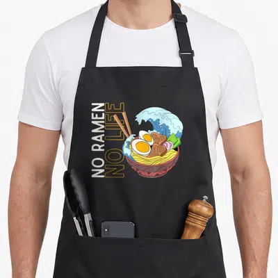 Tablier de cuisine noir avec illustration colorée d'un bol de ramen et texte vertical No Ramen No Life.