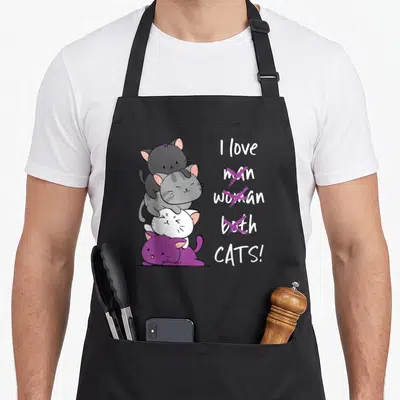 Tablier de cuisine noir avec trois chats colorés en pile et un message humoristique sur les chats.
