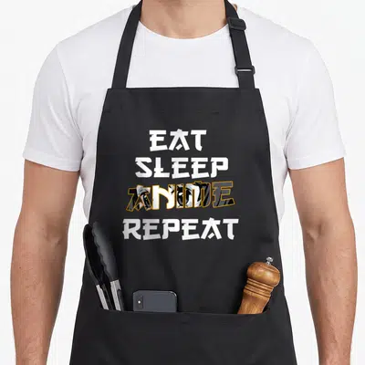 Tablier de cuisine noir avec l'inscription Eat Sleep Anime Repeat en typographie stylisée blanche et noire.