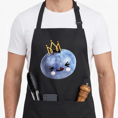Tablier de cuisine noir avec une myrtille princesse kawaii coiffée d'une couronne dorée et un visage souriant.