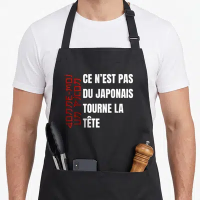 Tablier de cuisine noir avec ce n'est pas du japonais et des caractères rouges verticaux sur le côté gauche.