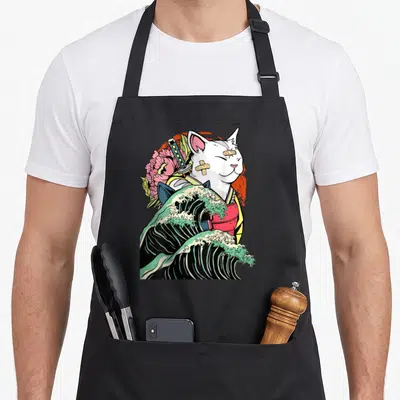 Tablier de cuisine noir avec illustration d'un chat blanc samouraï ninja sur une grande vague verte et rose.