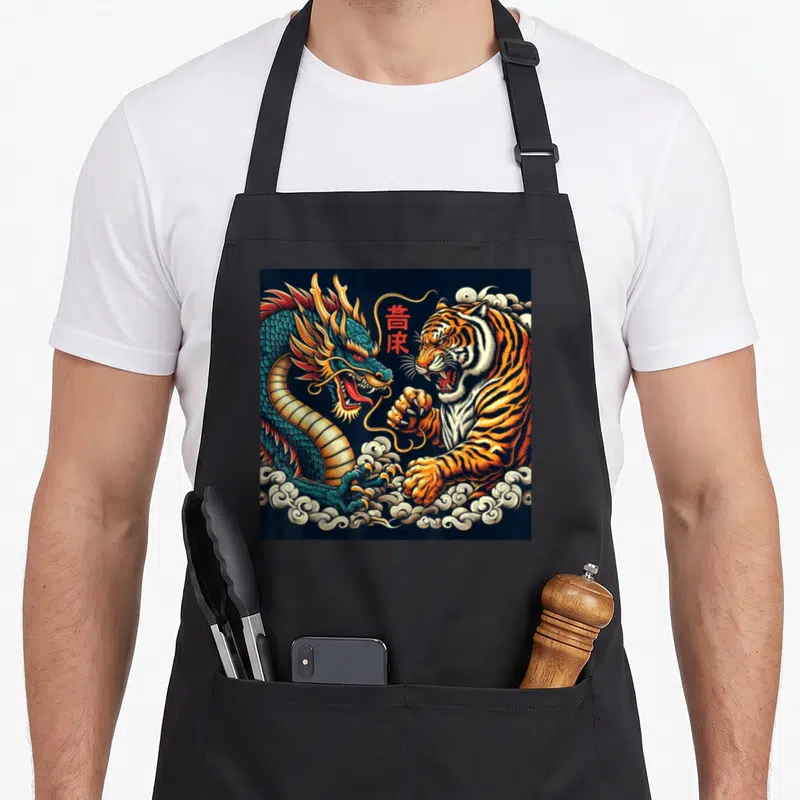 Tablier de cuisine noir avec illustration d'un dragon bleu et d'un tigre orange s'affrontant dans des nuages stylisés.
